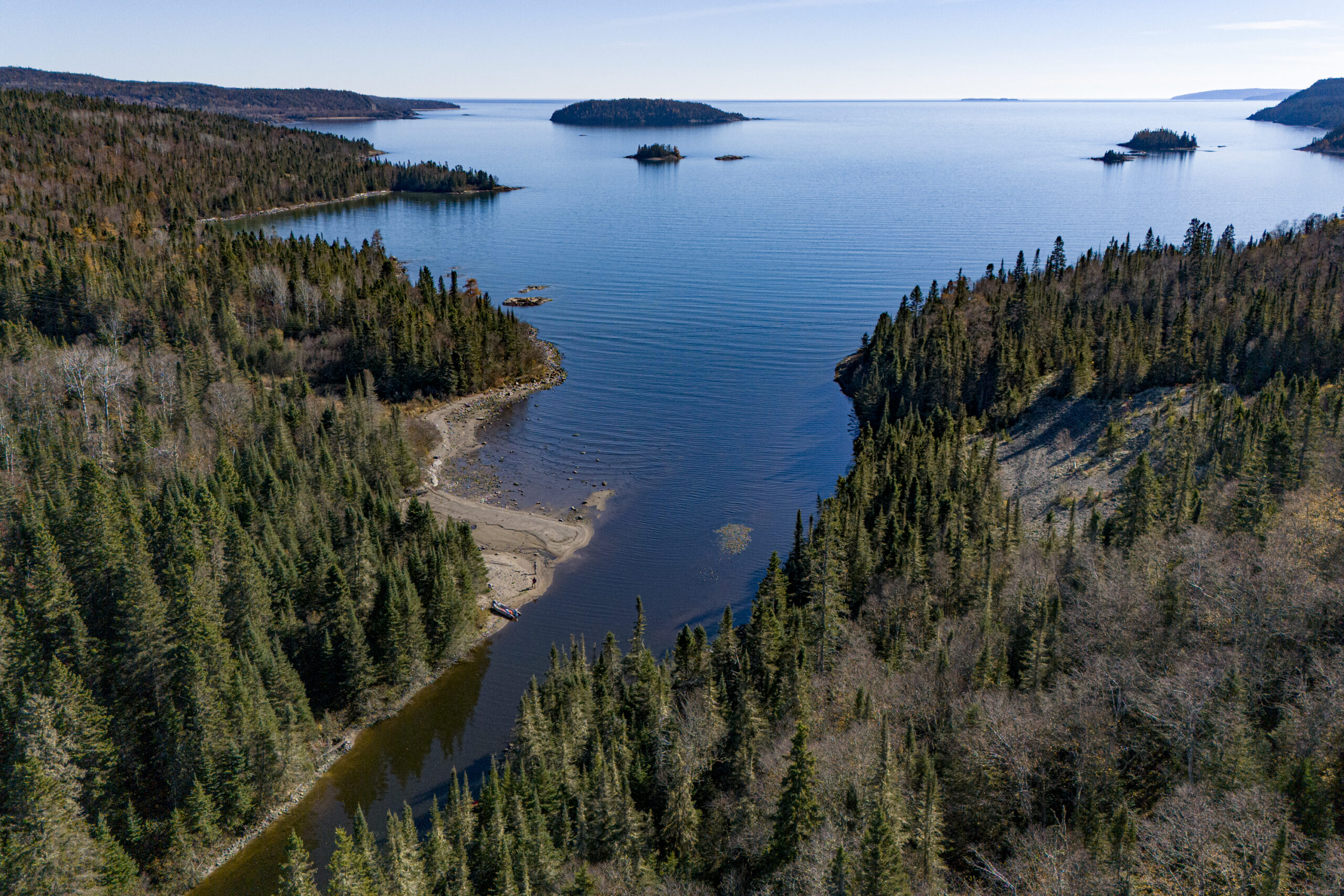 Aerial view of a lake along a creek, running through boreal forest