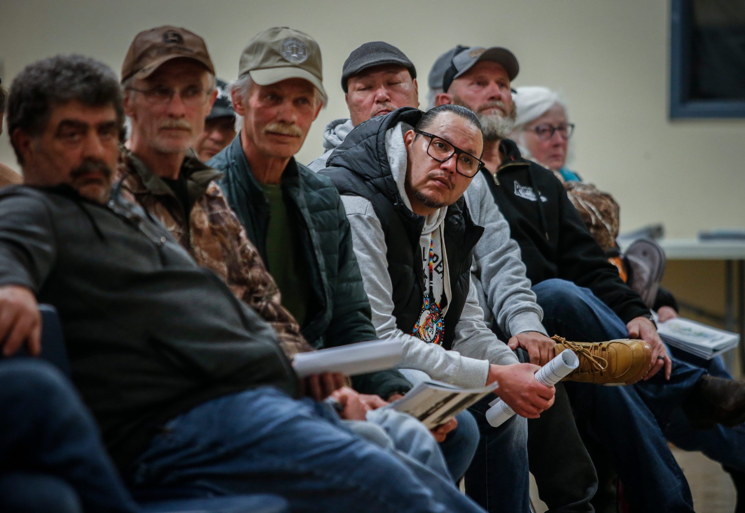 a row of men sit in a crowd