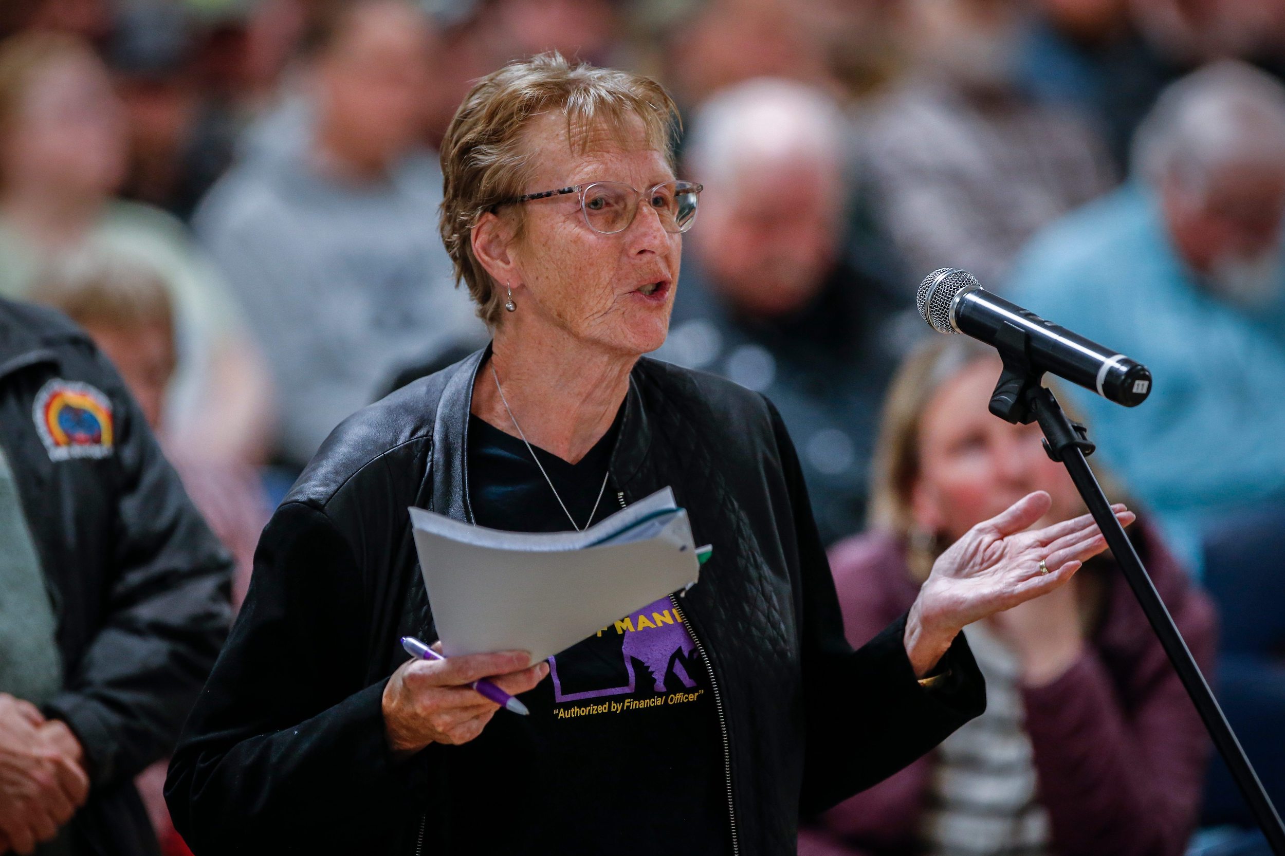 A woman speaks at a microphone