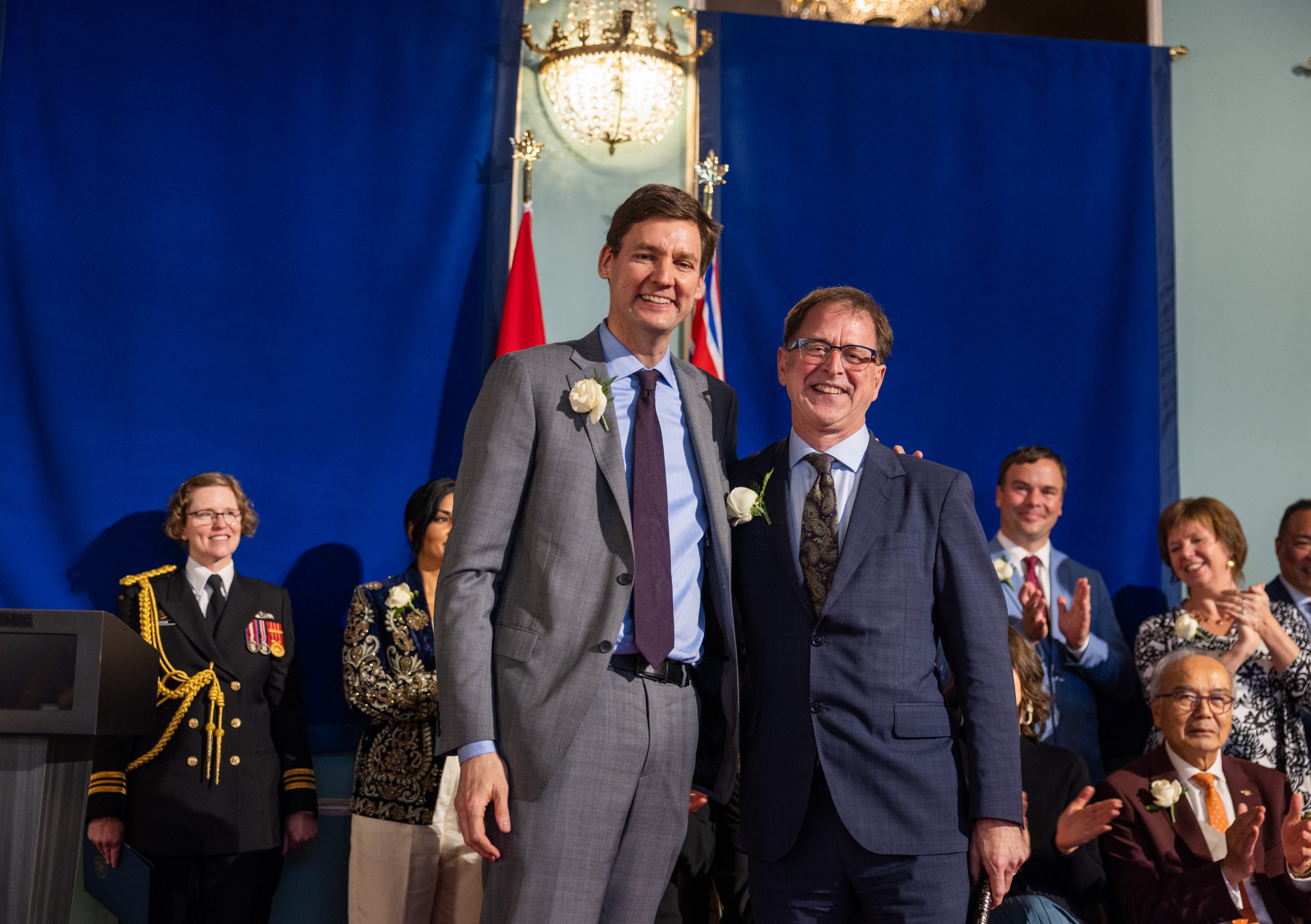Premier David Eby and Energy Minister Adrian Dix stand side by side at the swearing in ceremony for the BC NDP cabinet in 2024