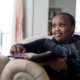 Margaret Wanyoike sits on a couch in her energy-efficient apartment in New Westminster, B.C.