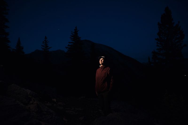 A hiker in the dark under stars