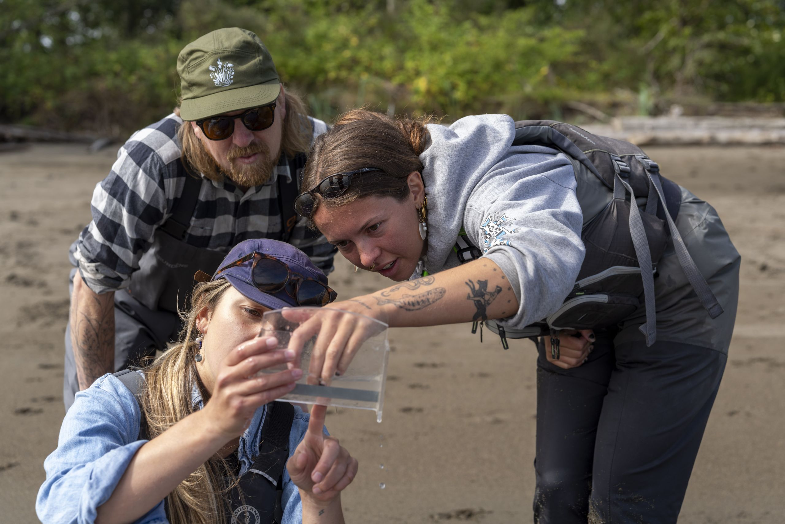 Biologist Daniel Stewart and salmon conservation technicians take a closer look at the juvenile salmon