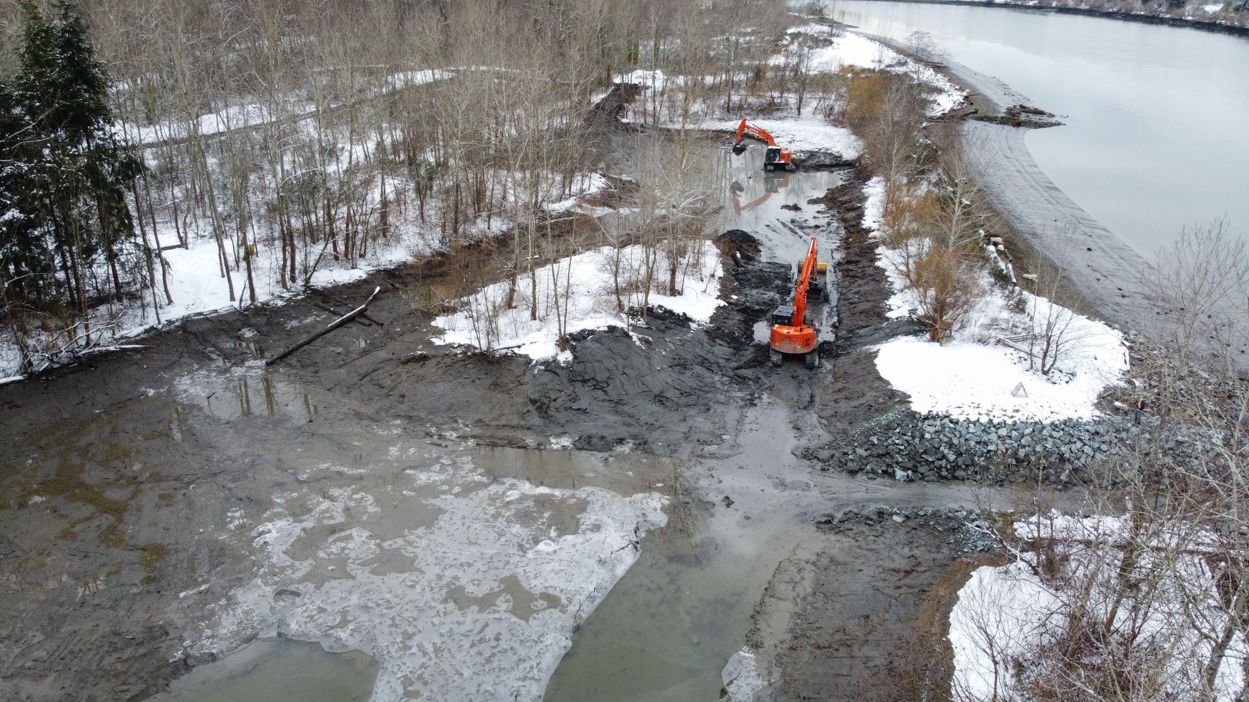 An aerial photo of two big orange machines working in the woods island marsh during restoration earlier this year