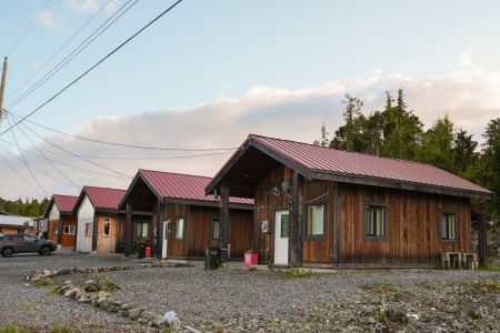 A row of modest wood homes with red metal roofs
