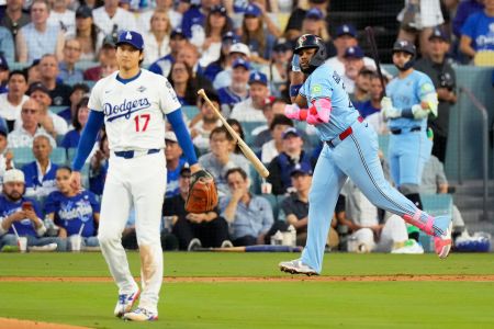 Toronto Blue Jays' Vladimir Guerrero Jr. runs behind Los Angeles Dodgers pitcher Shohei Ohtani as fans watch behind them during the World Series