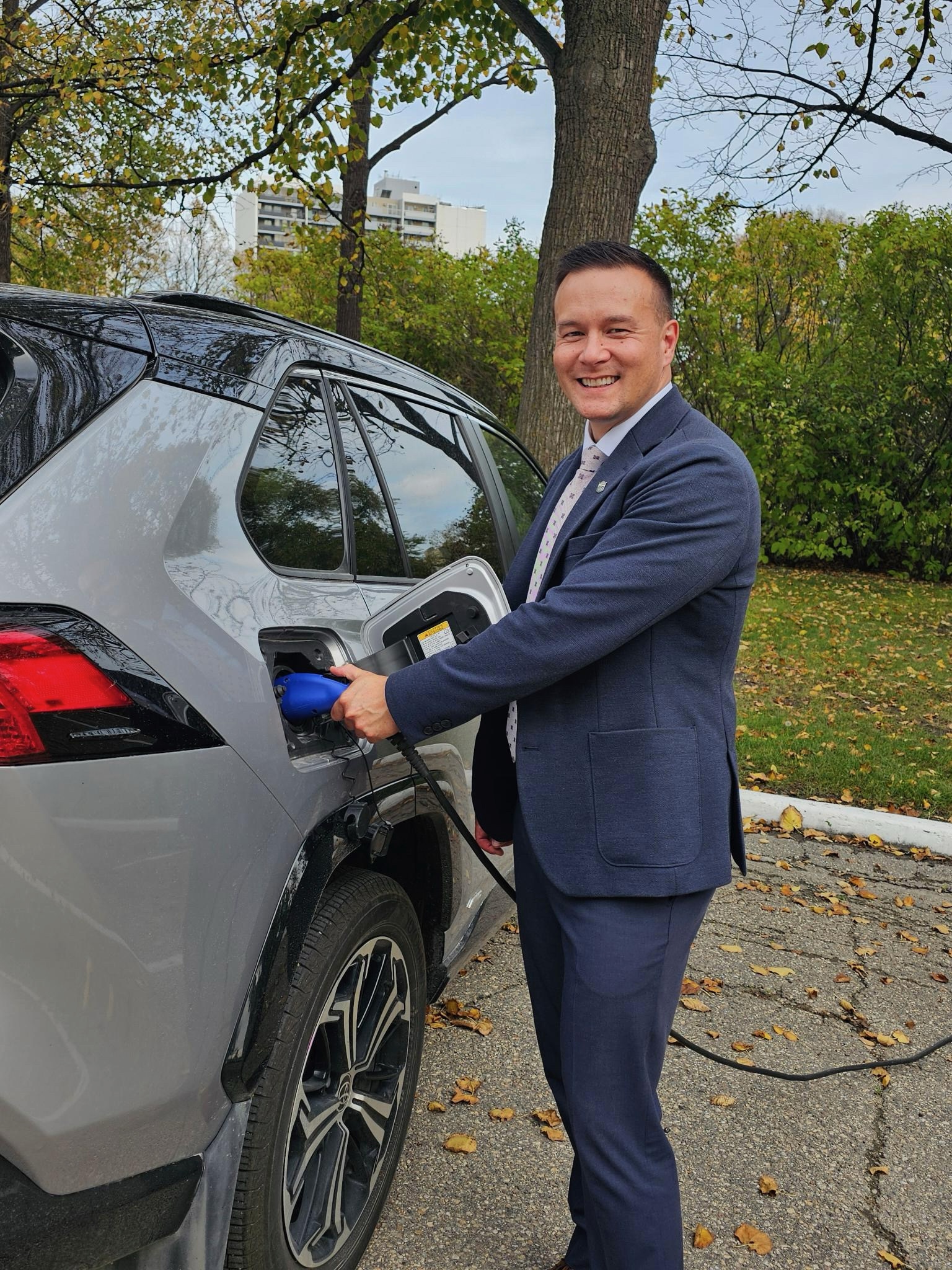 Environment and Climate Change Minister Mike Moyes charging his electric vehicle