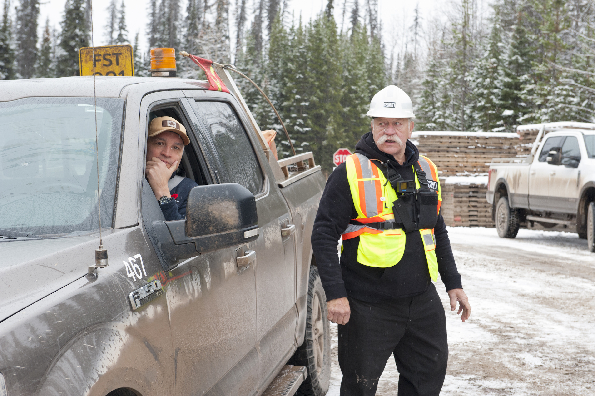 Two private security contractors at a Coastal GasLink worksite, one in a truck and the other on foot, in 2022