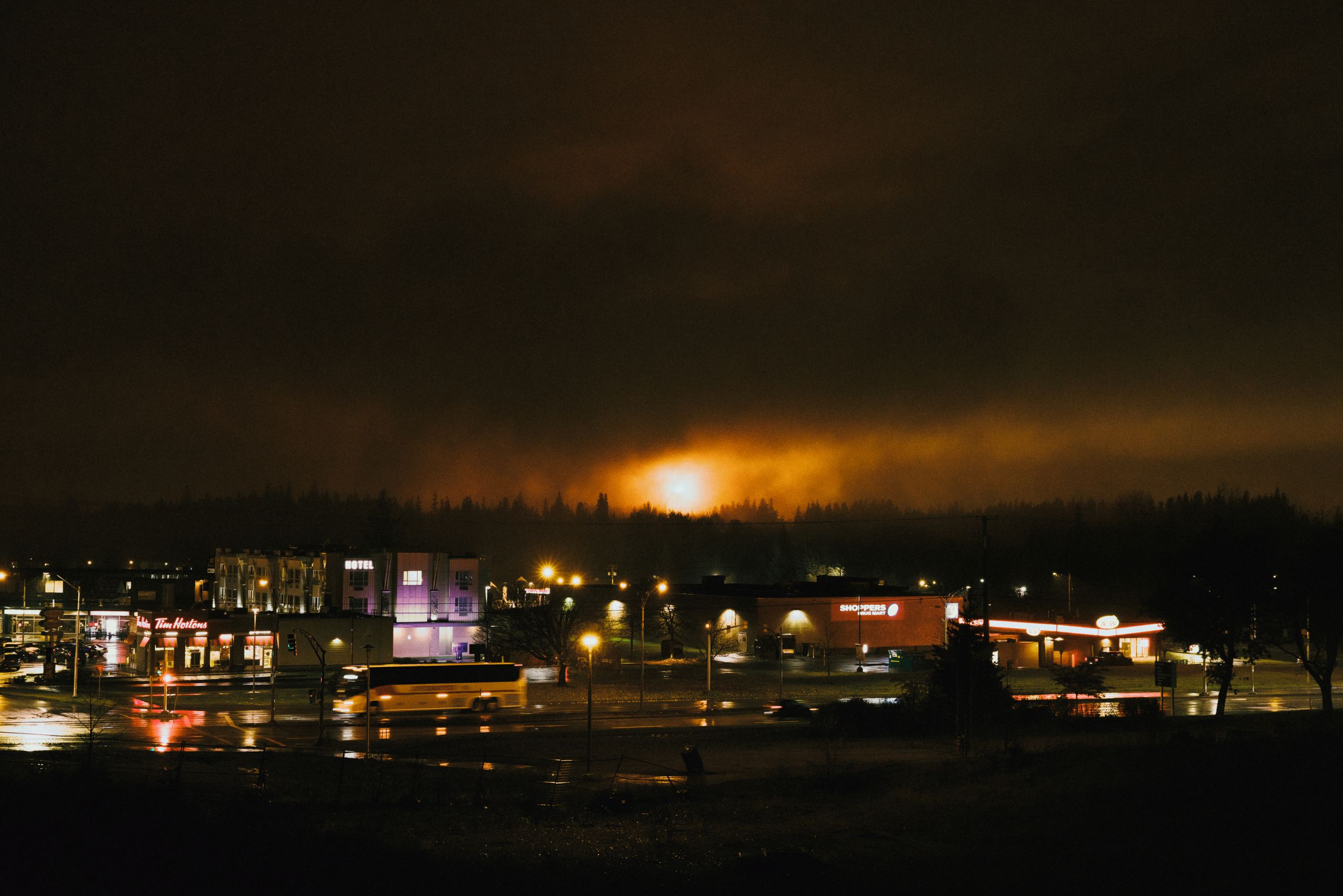 An ominous orange glow looms in the sky behind a nighttime scene in Kitimat, B.C.
