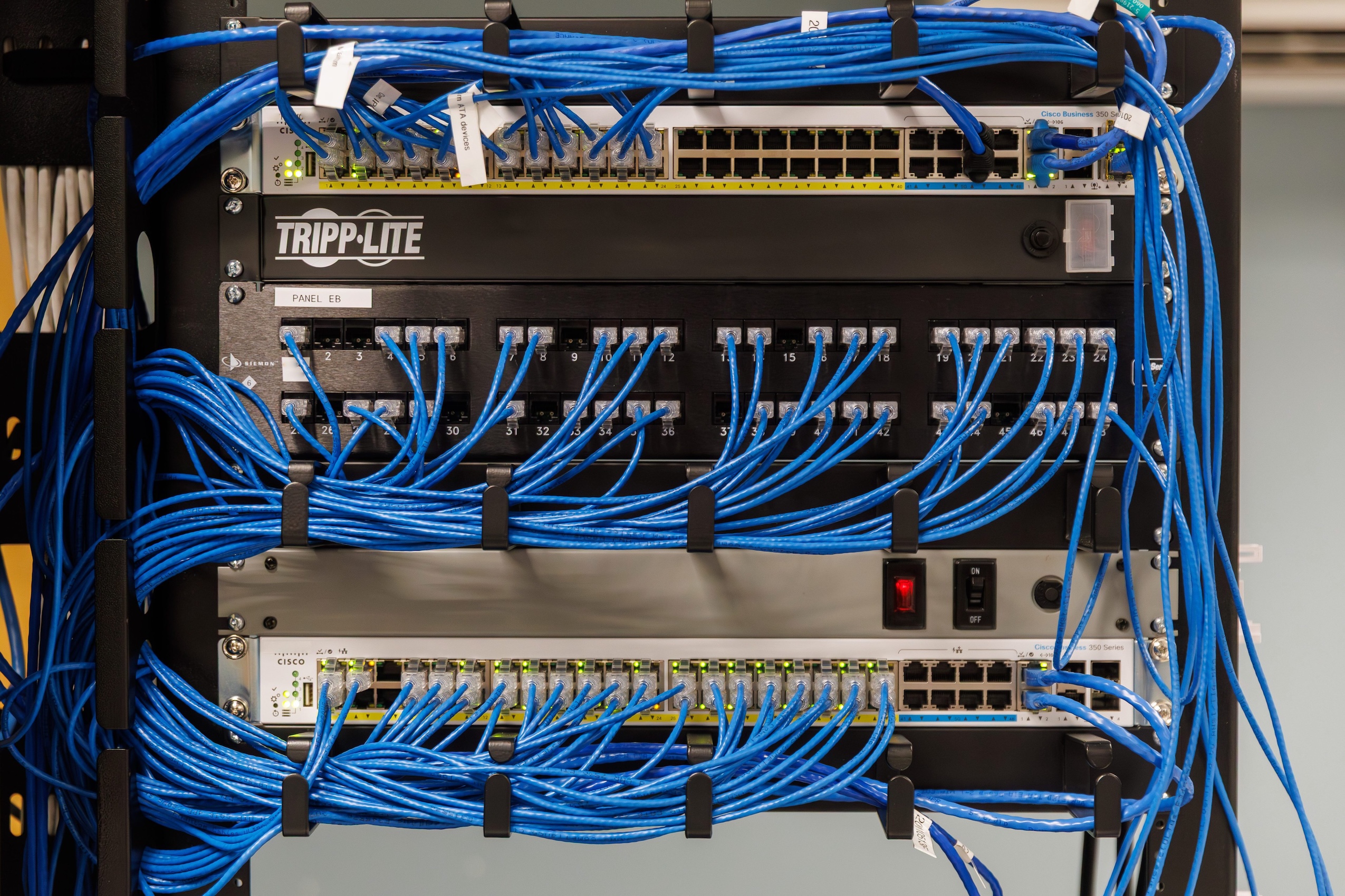 Several blue wires plug into a server rack