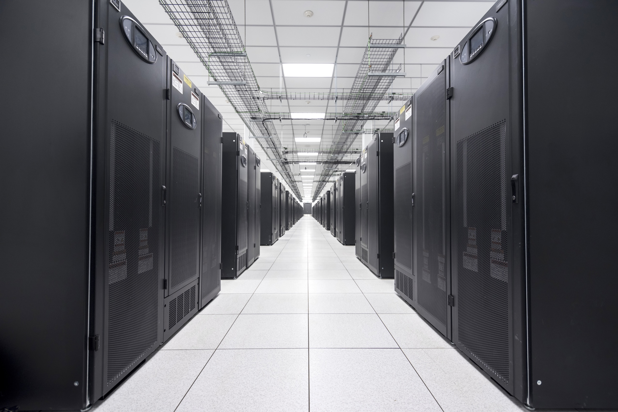 A long hallway of black server cabinets inside a Manitoba data centre
