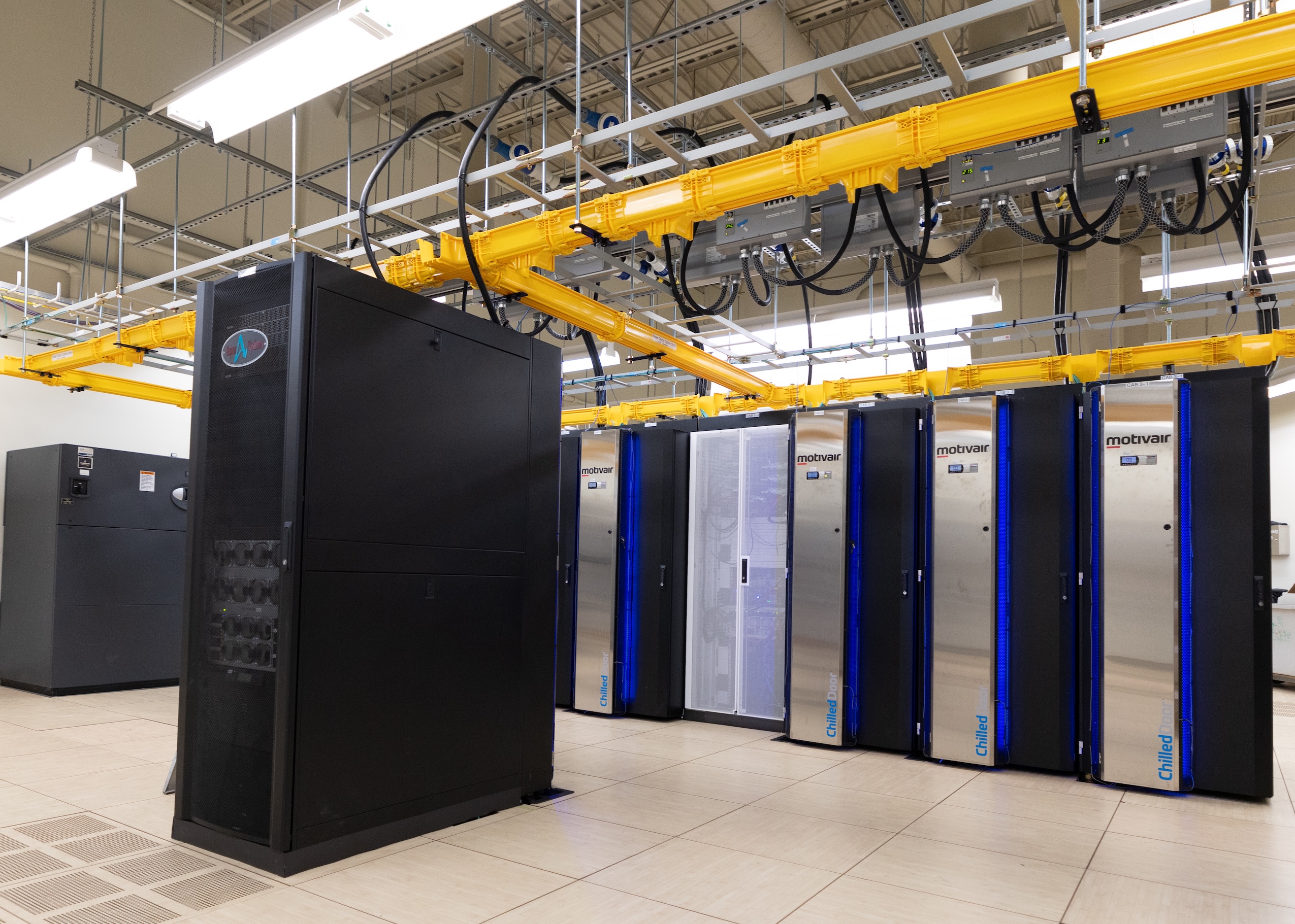 Yellow tubing connects to large server cabinets in the University of Manitoba's supercomputer data centre