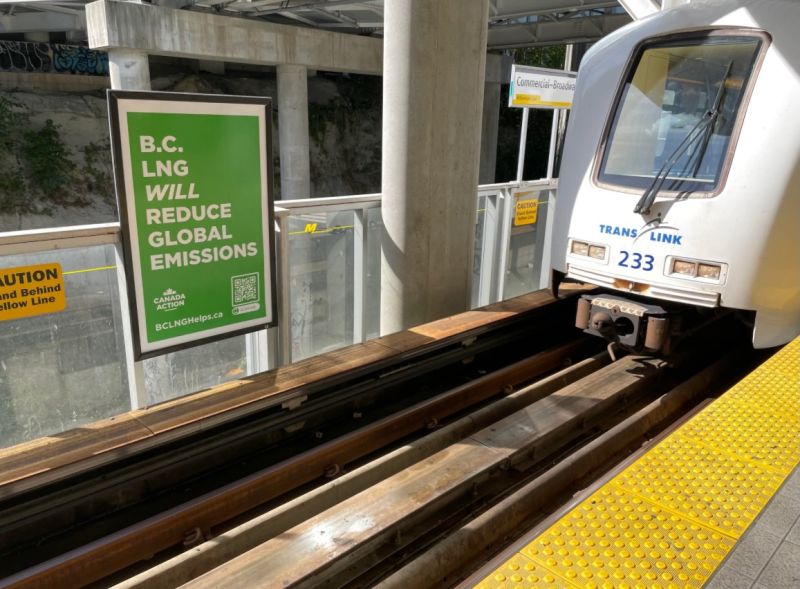 An advertisement in a public transit station reads, "B.C. LNG will reduce global emissions."