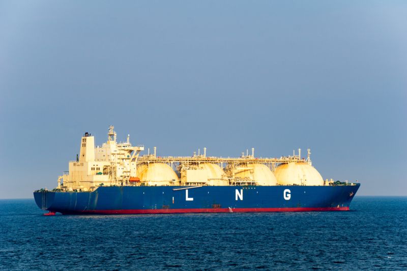 a liquefied natural gas tanker at sea. The vessel is red white and blue