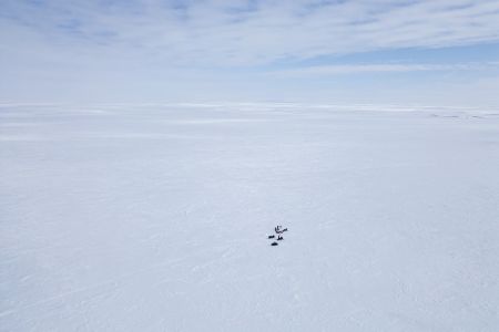 An aerial view of a team of researchers works on Arctic sea ice.