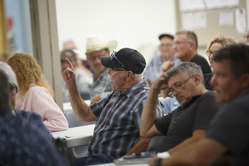 A man pointing his finger and speaking angrily at a surface rights meeting in Warburg, Alta.