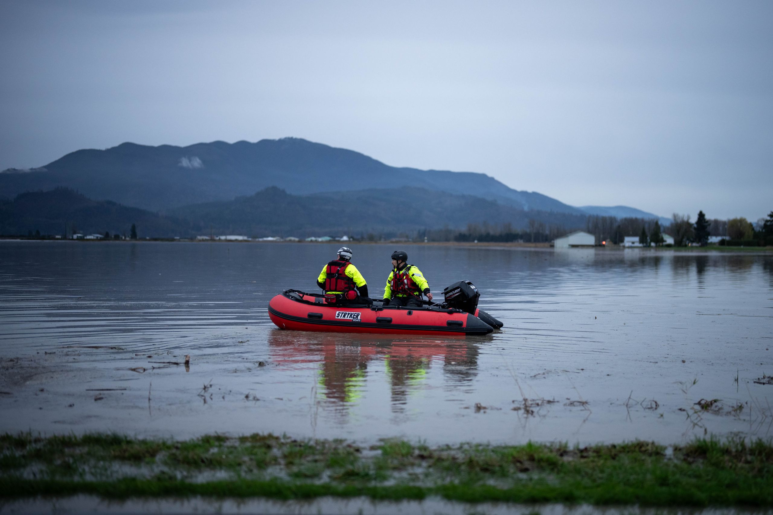 A photo of two search and rescue team members in a red inflatable boat on a flood area of Abbotsford, B.C.