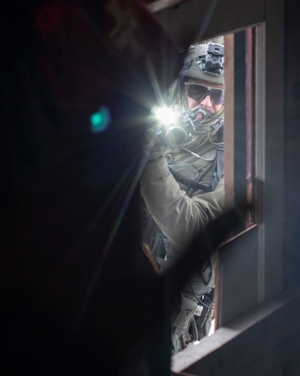 An RCMP officer aims a rifle into a one-room wooden home on Wet’suwet’en territory where land defenders gathered in November 2021 in opposition to construction of the Coastal GasLink pipeline.