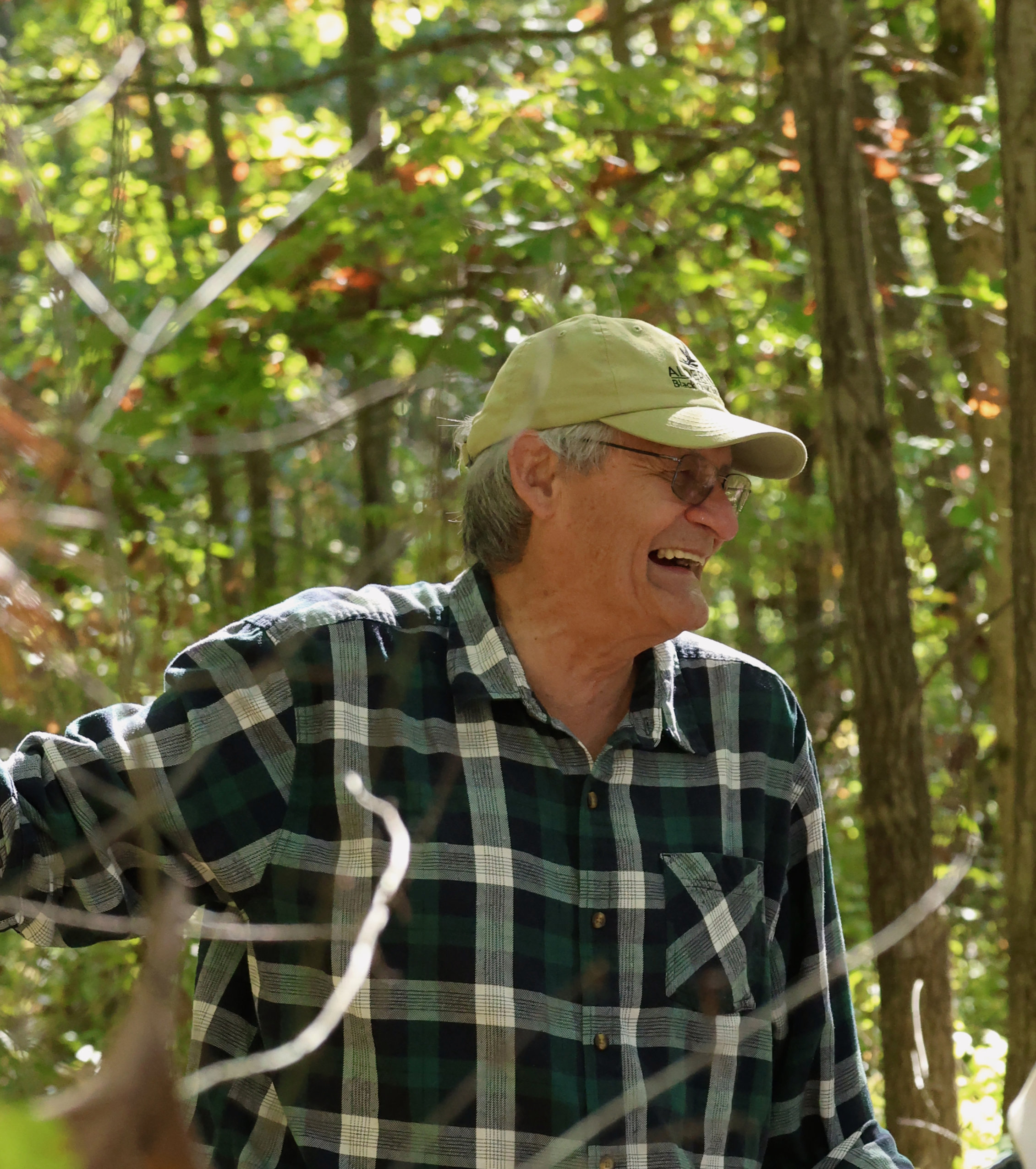 Anishinaabe wildlife biologist and one of the founders of the Black Oak Savanna, Rick Beaver, smiling in the woods while leading a guided tour through the Alderville Black Oak Savanna during Prairie Day on October 3, 2025.
