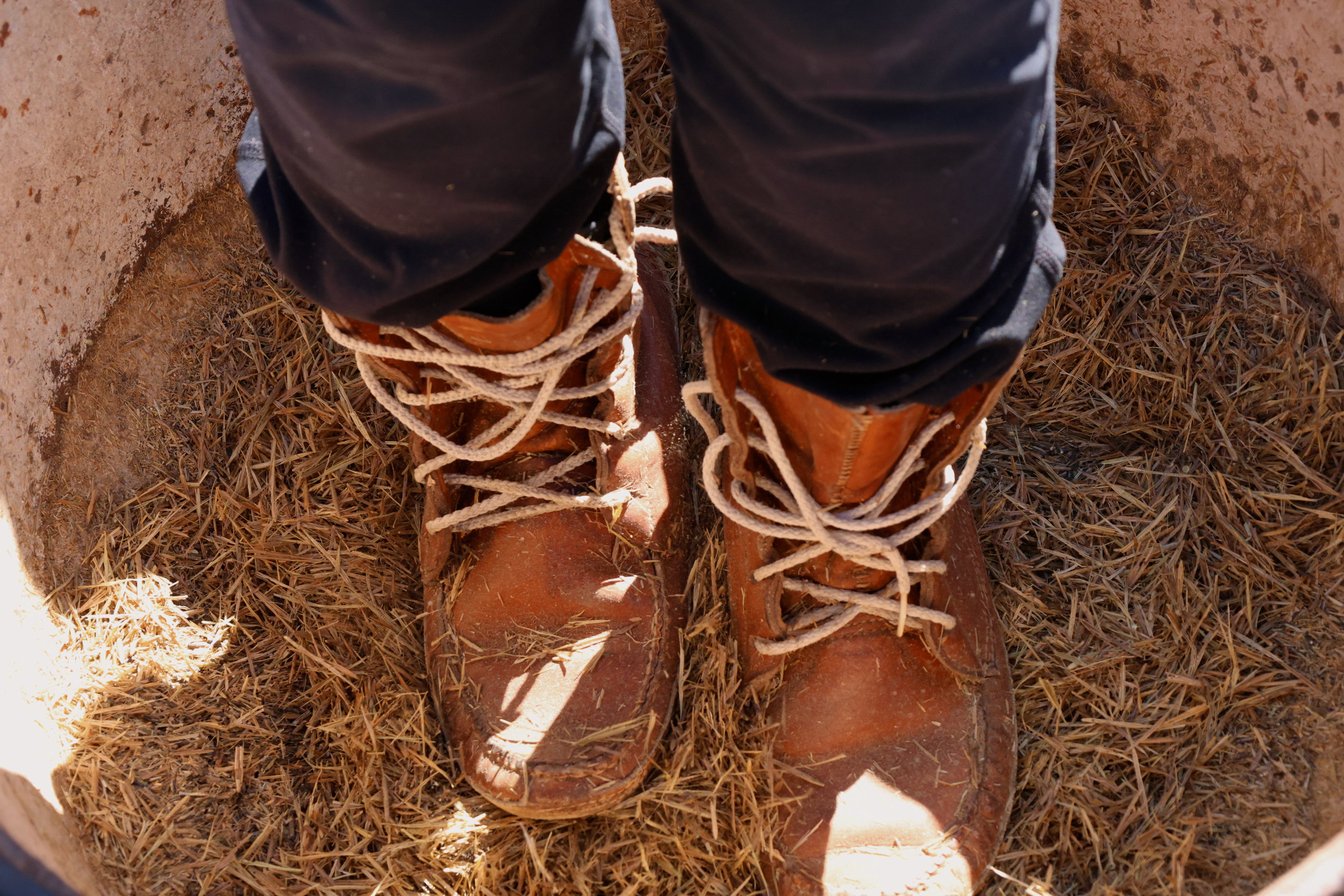 A close up of Rageous May-Vokes, a young Anishinaabe woman, wearing high-cuffed moccasins and dancing on rice during the Alderville Black Oak Savanna’s 2025 Prairie Day on October 3, 2025.