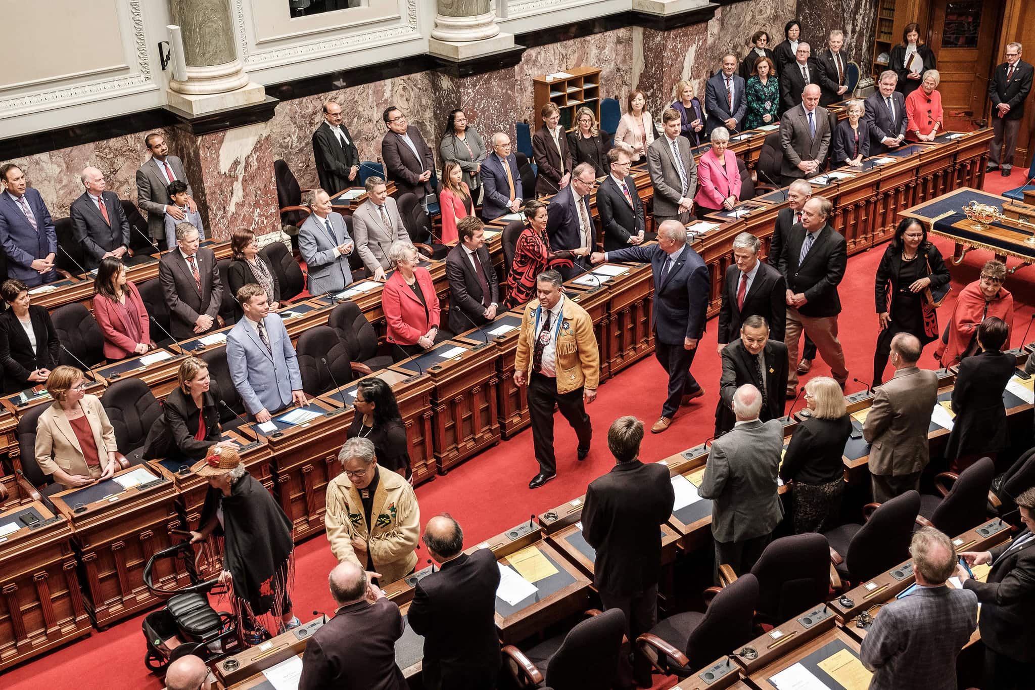 Indigenous leaders head a procession of politicians leaving the BC legislature's chamber following the unanimous passage of the Declaration of the Rights of Indigenous Peoples Act