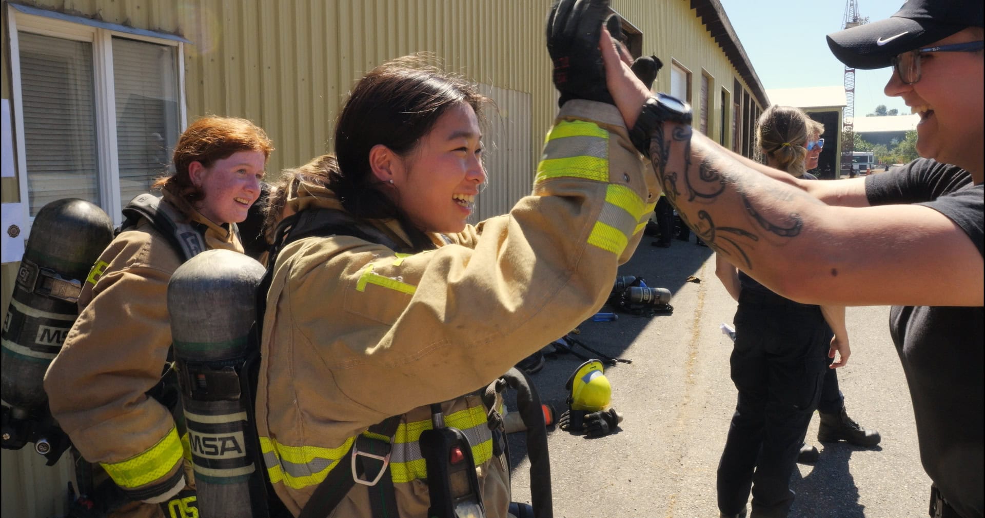 A teenage girl is seen wearing firefighting gear at a camp to learn how to firefight. Photo: Nova Ami & Velcrow Ripper