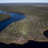 An aerial image of a large river bending its way through a vast natural landscape.