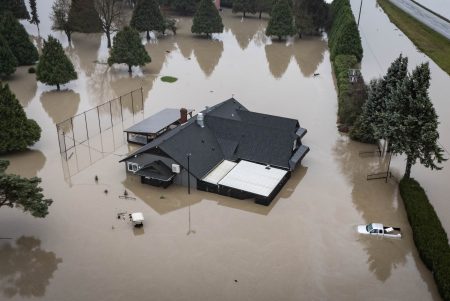 Floodwaters surround a house and vehicles in Abbotsford B.C.