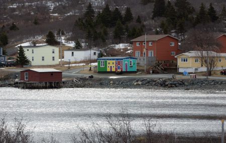 A small, colourful building stand out among others on a coastal shoreline