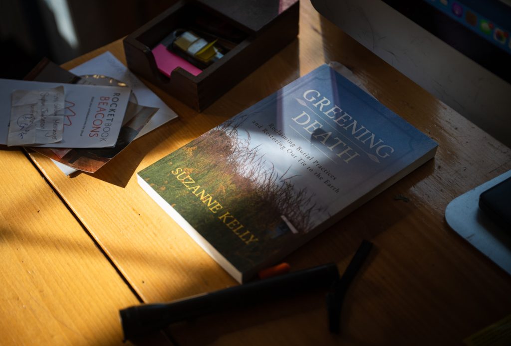 A book called Greening Death sits on a desk.