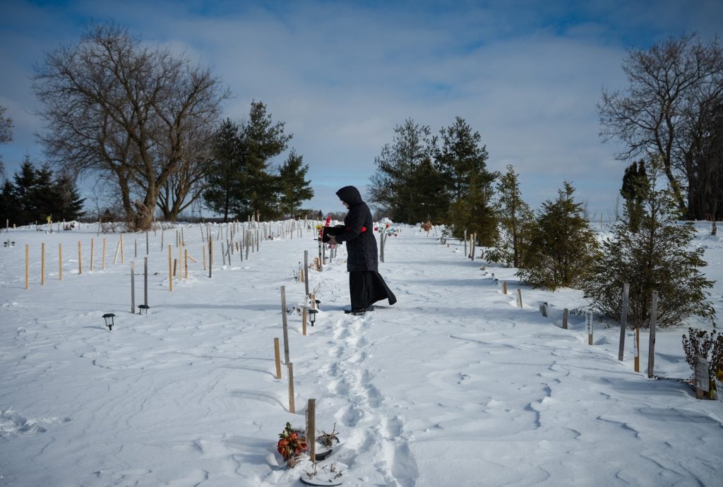A woman walks among grave-sites at the Toronto Muslim Cemetery in Richmond Hill, Ont., in wintertime.