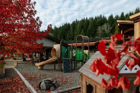 A playground next to a community building with solar panels on the roof
