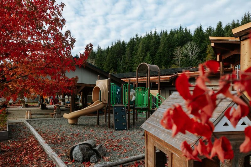 A playground next to a community building with solar panels on the roof