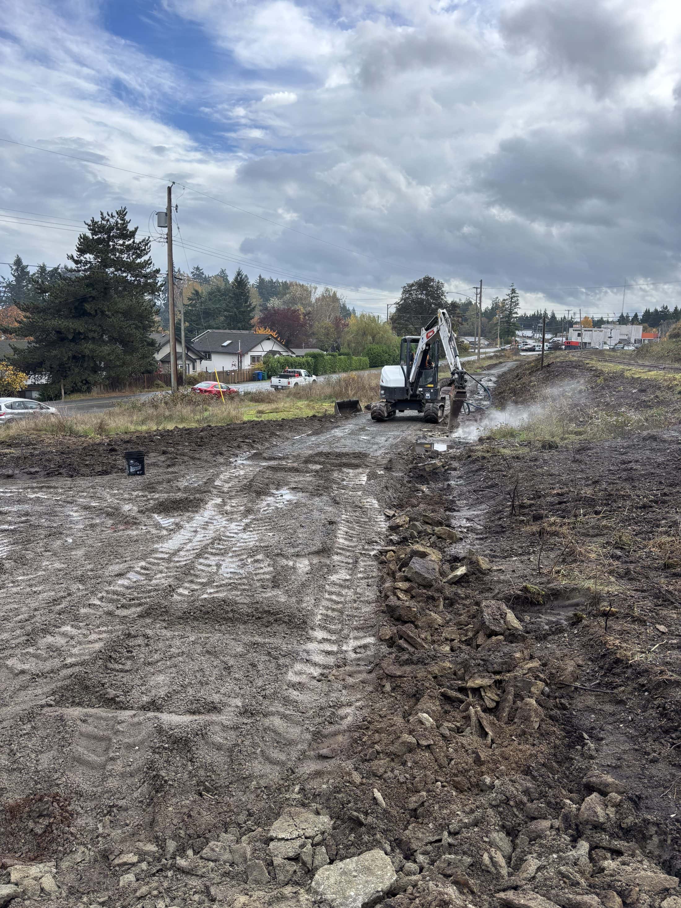 A muddy path in the foreground with a digger in the background