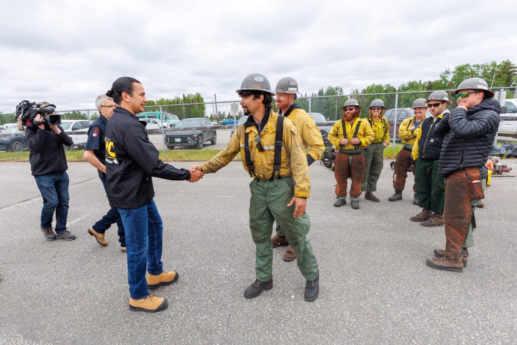 Manitoba Premier Wab Kinew greets wildfire fighters.