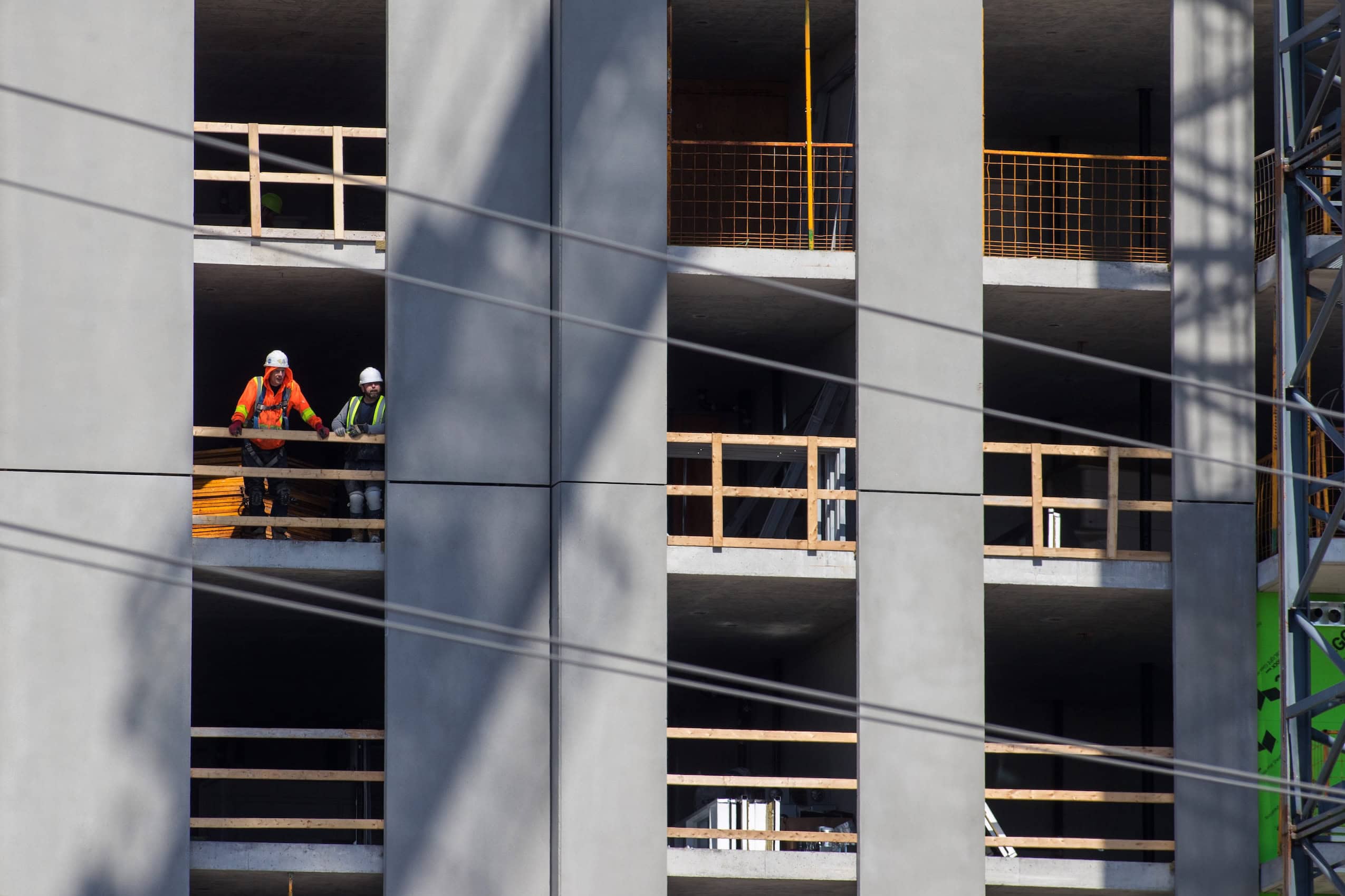 A building construction site with construction workers standing on an open floor.