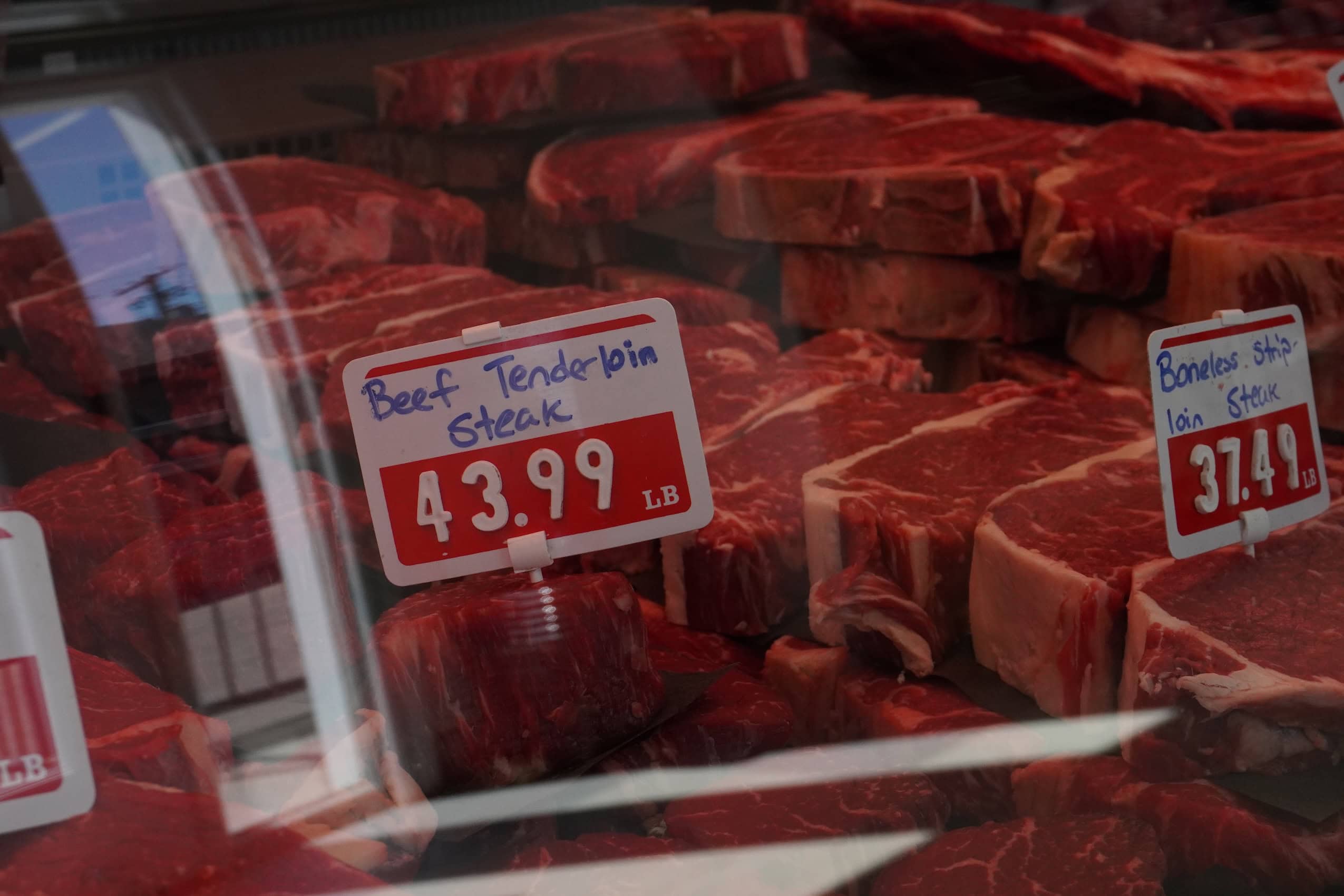 A meat display case showing different cuts of raw beef steak.