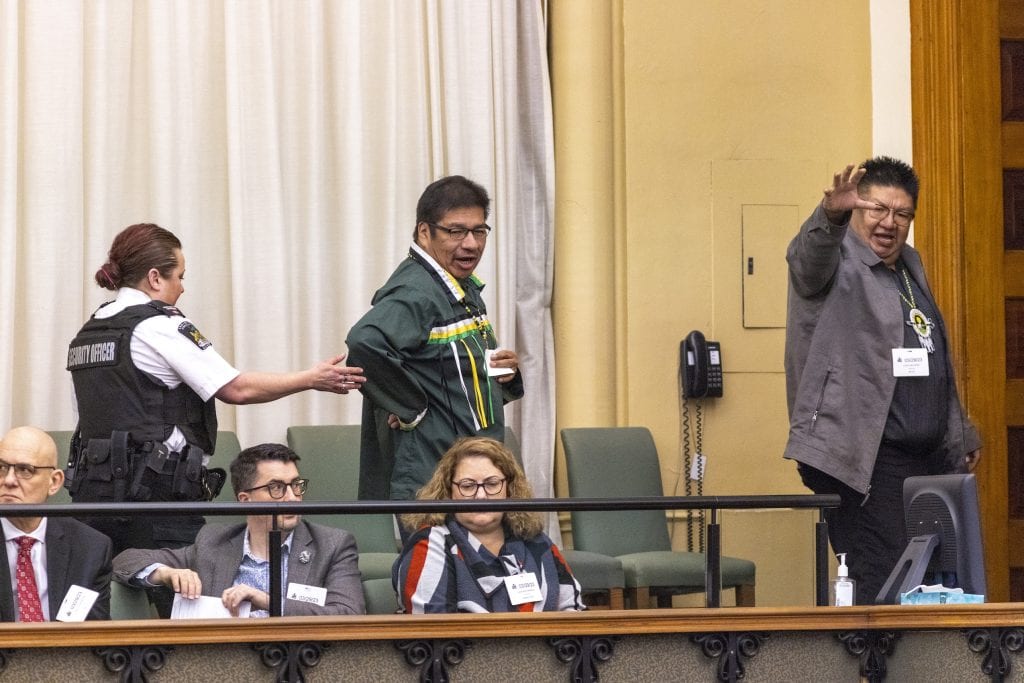 A security officer escorts two people out of a viewing gallery at the Ontario legislature.