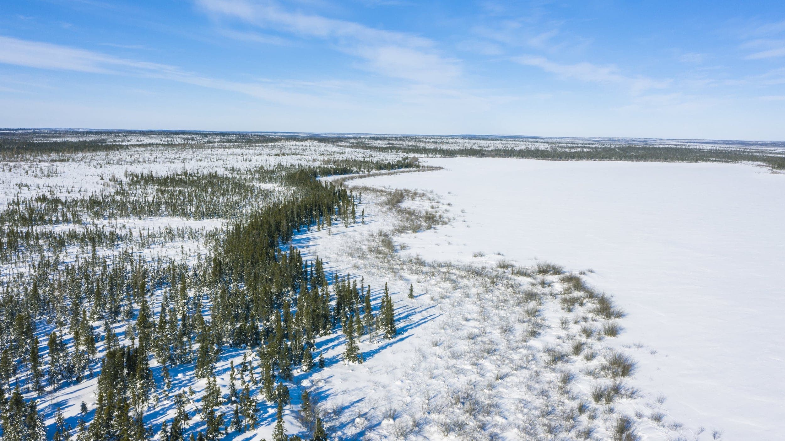 An aerial view of a shoreline in the Seal River watershed in northern Manitoba, with snow covering the landscape.