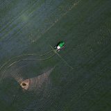 An aerial image of farm equipment in a field in Saskatchewan.