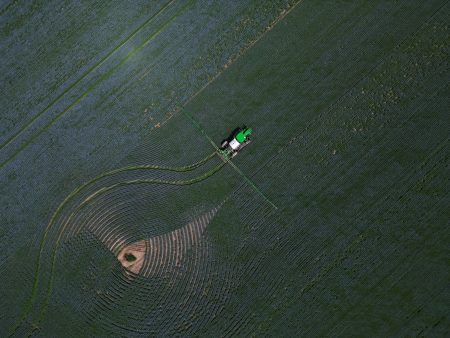 An aerial image of farm equipment in a field in Saskatchewan.