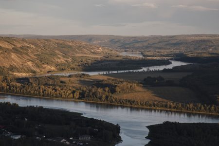 A river running through forested land, viewed from an aerial distance.