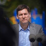 B.C. Premier David Eby pauses while speaking into a microphone.