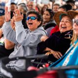 Squamish people are gathered in laughter, seated in rows.