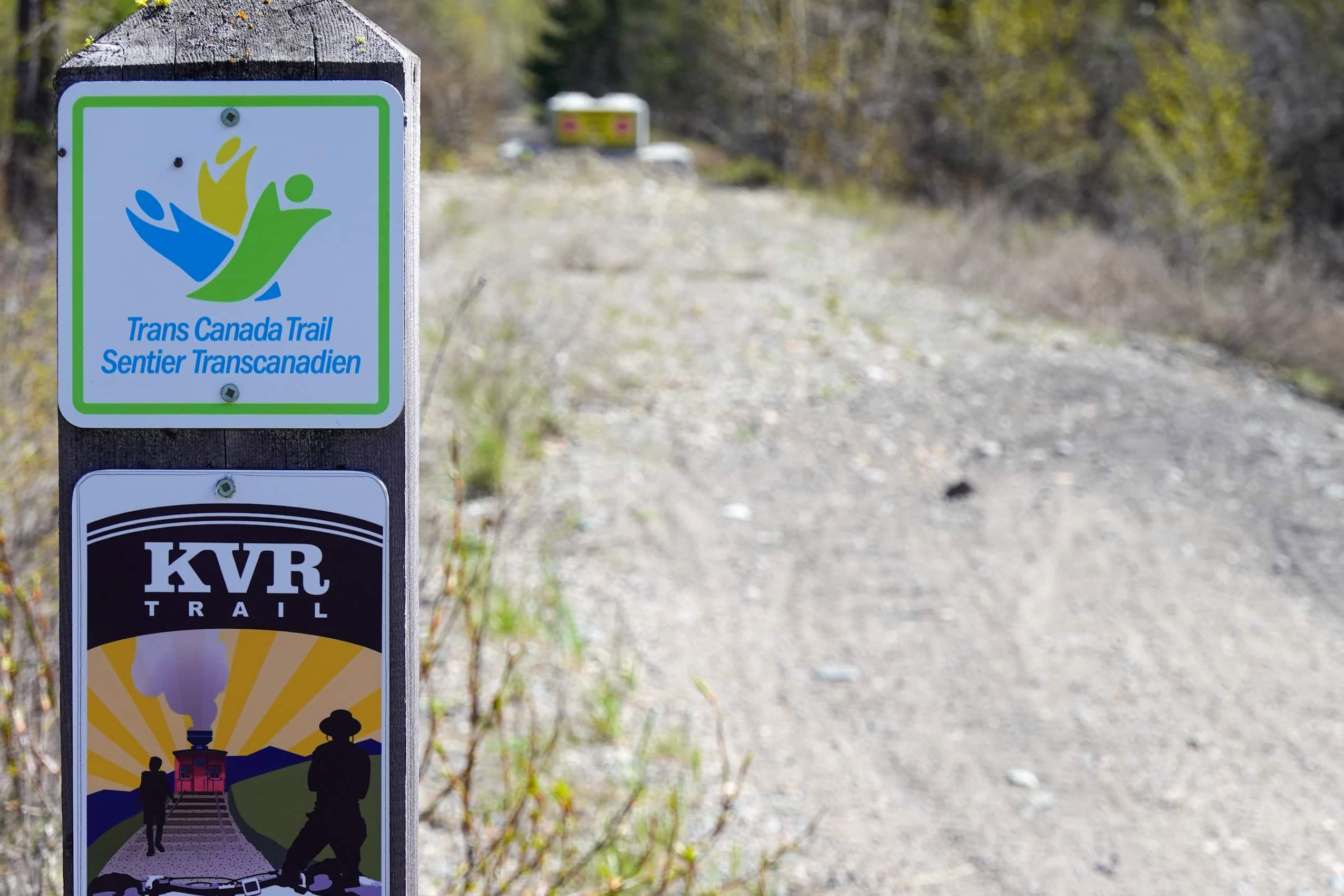 A sign at the start of a dirt roading, reading "TransCanada Trail" and "KVR."
