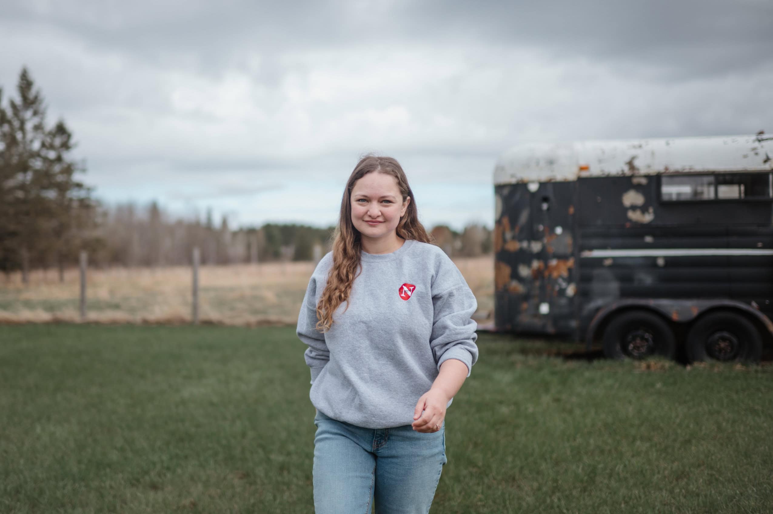 Reporter Leah Borts-Kuperman walks toward the camera wearing a sweatshirt with The Narhwhal's logo on it.