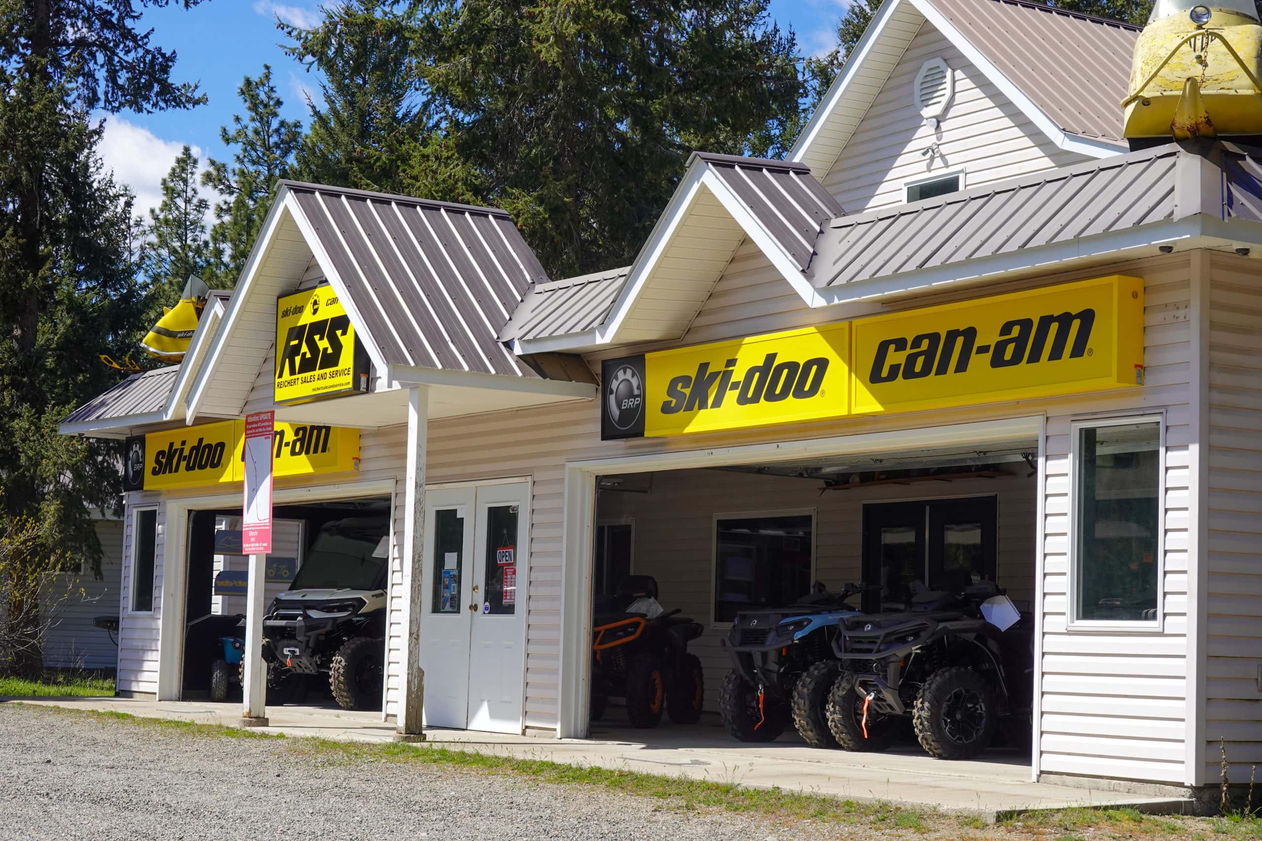 The outside of a ski-doo and ATV shop with bright yellow bannering.