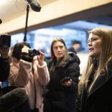 Amber Bracken speaks in front of journalists with cameras and microphones