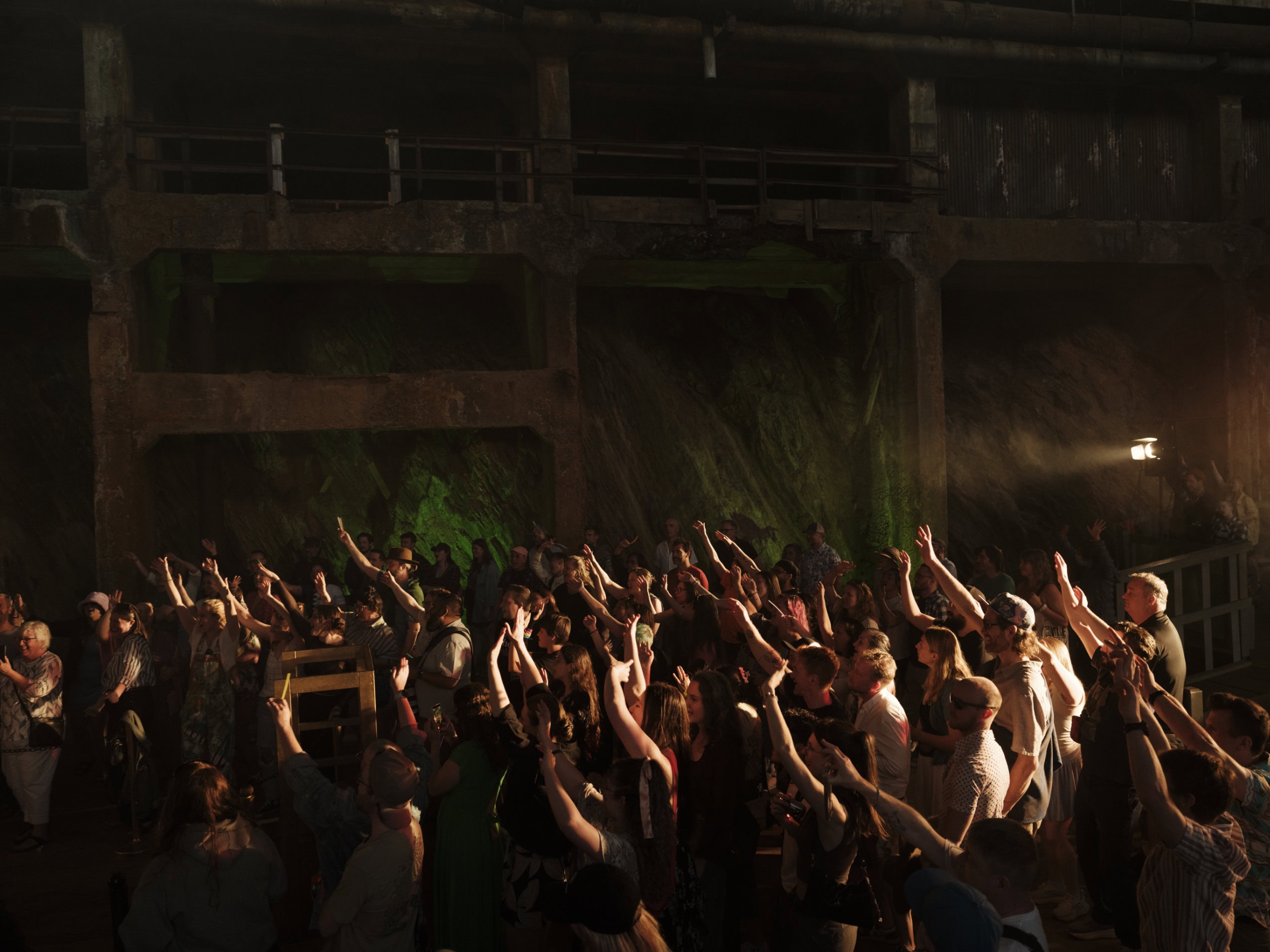 Crowd members raise their hands during a drag performance at the Britannia Mine Museum in Britannia Beach, B.C.