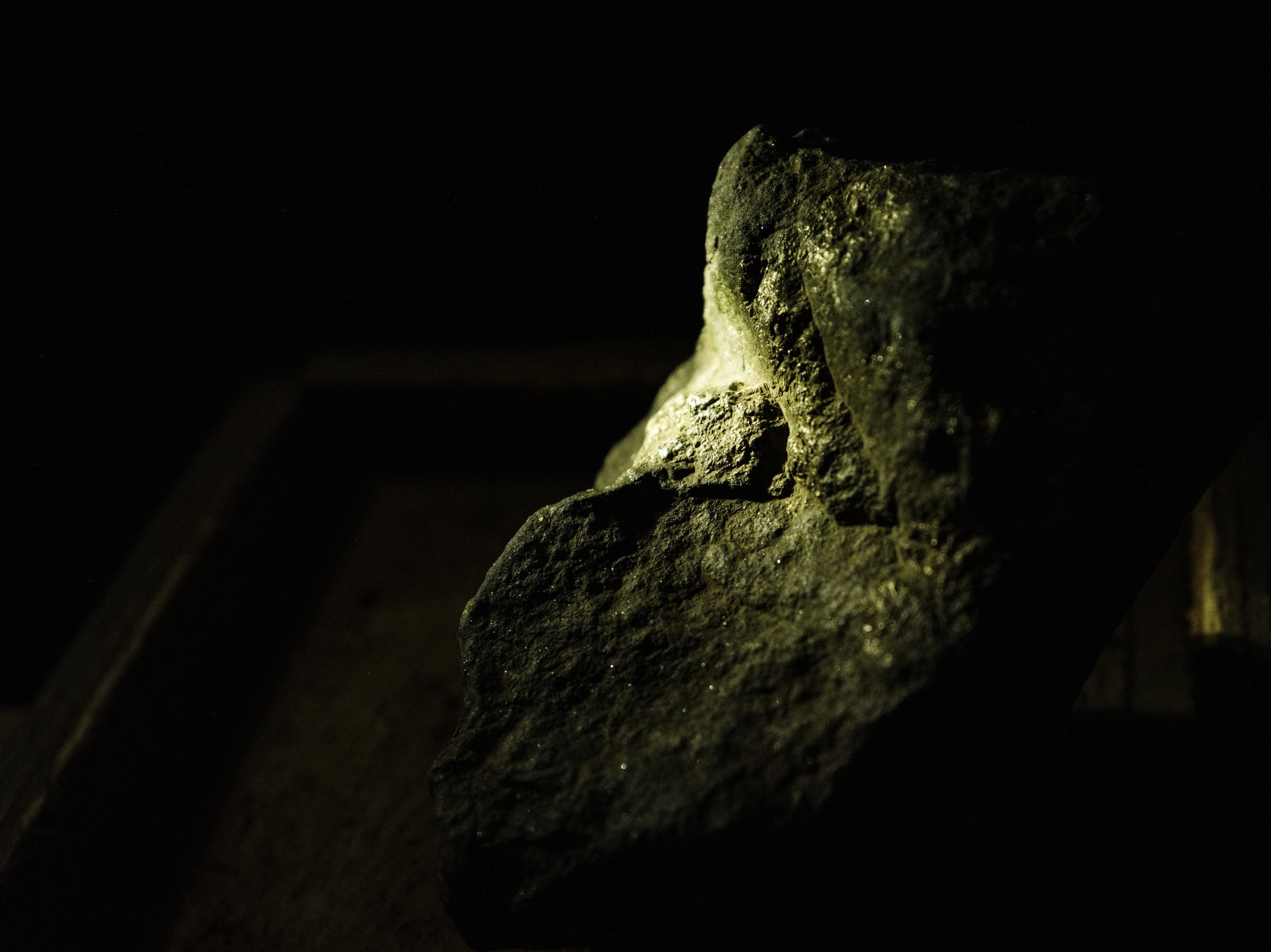 Unrefined copper glints on an ore sample on a black background.